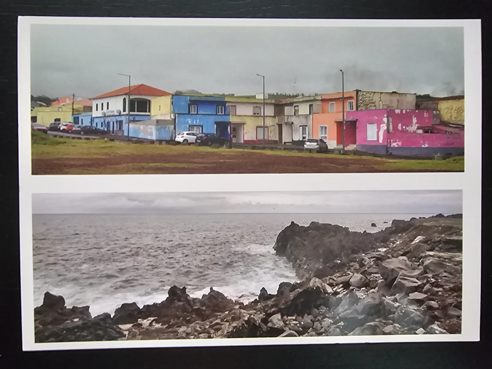Das Bild zeigt zwei Ansichten: oben eine Reihe bunter Häuser mit Autos und unten eine felsige Küste mit Wellen am Meer, alles unter bewölktem Himmel.
