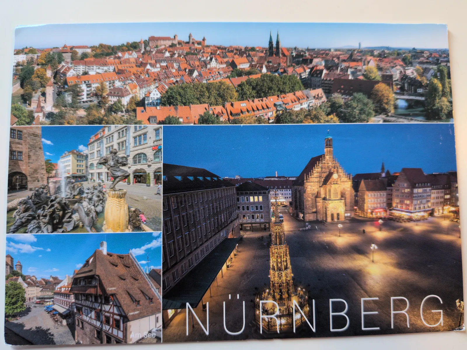 Das Bild zeigt eine Collage von Ansichten der Stadt Nürnberg, mit der Altstadt, einem Brunnen bei Tag und einem beleuchteten Platz bei Nacht, sowie dem Schriftzug "NÜRNBERG".
