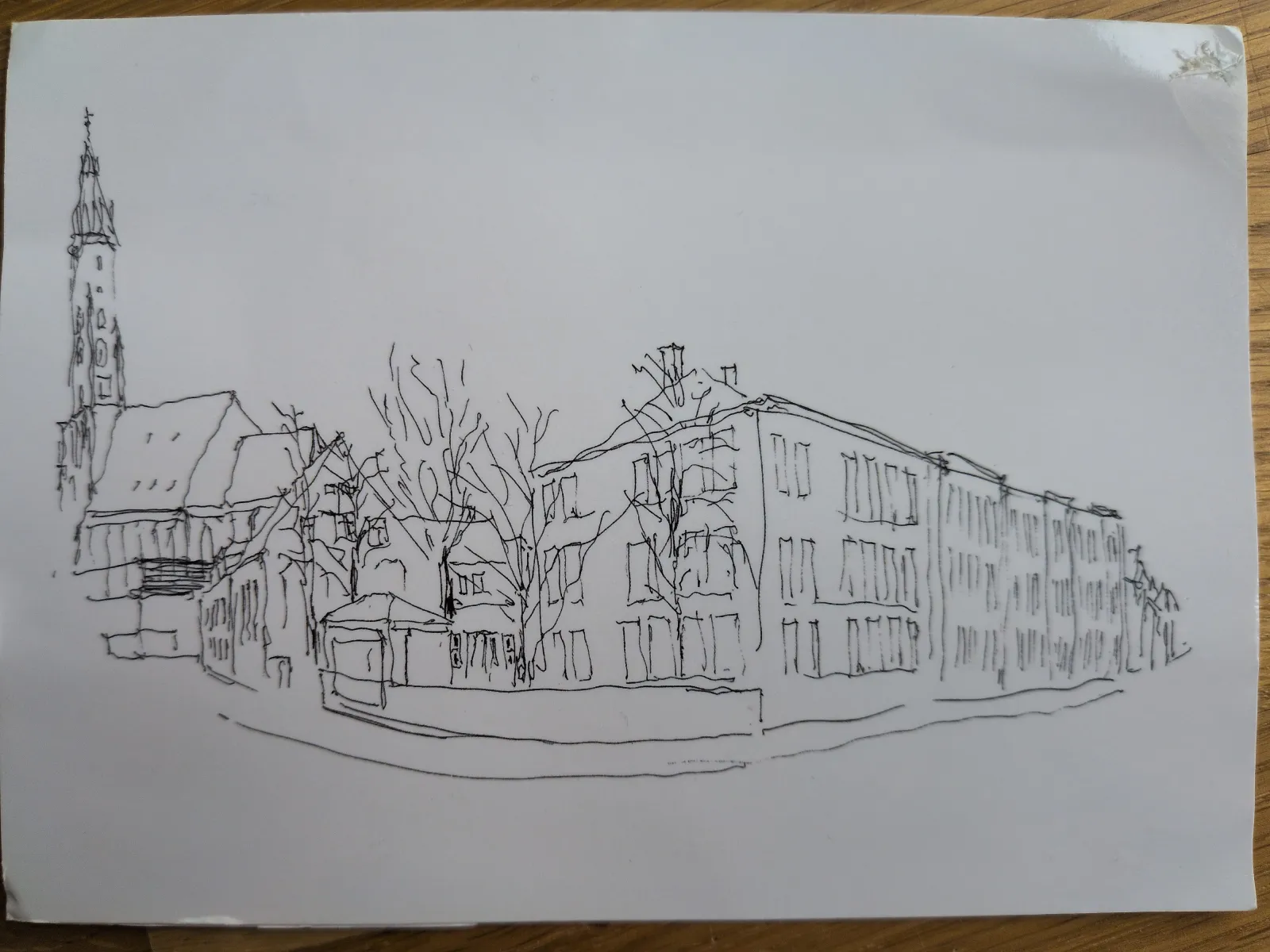 Strichzeichnung einer Stadtansicht mit einer Kirche, weiteren Gebäuden und kahlen Bäumen.