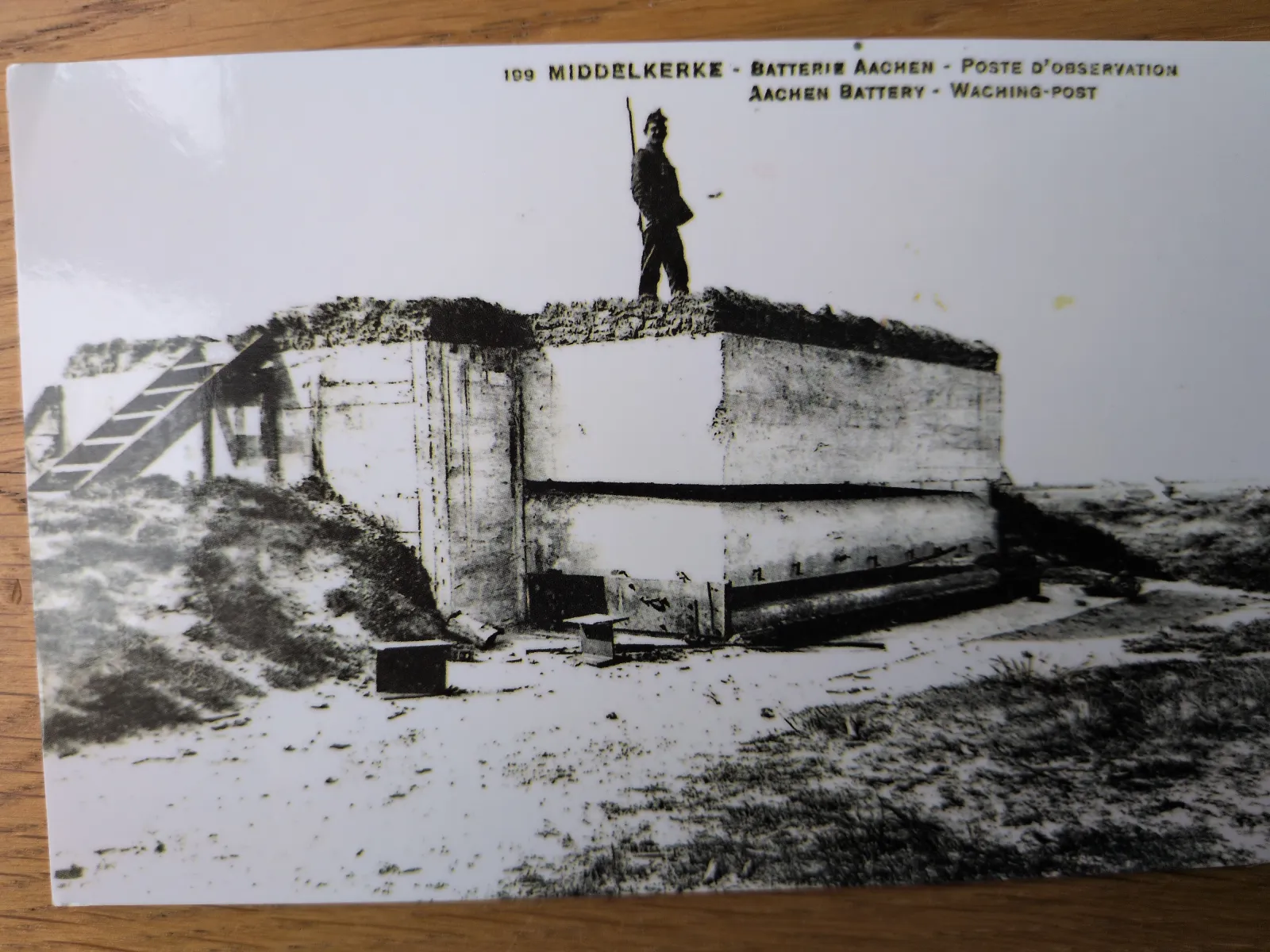 Ein Schwarz-Weiß-Foto zeigt einen Soldaten auf einem Beton-Beobachtungsposten in einer kargen Landschaft.