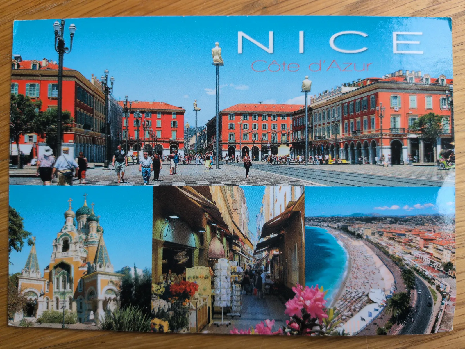 Eine Postkarte von Nizza an der Côte d'Azur, die in einer Collage belebte Stadtansichten, eine Kirche und die berühmte Küste zeigt.