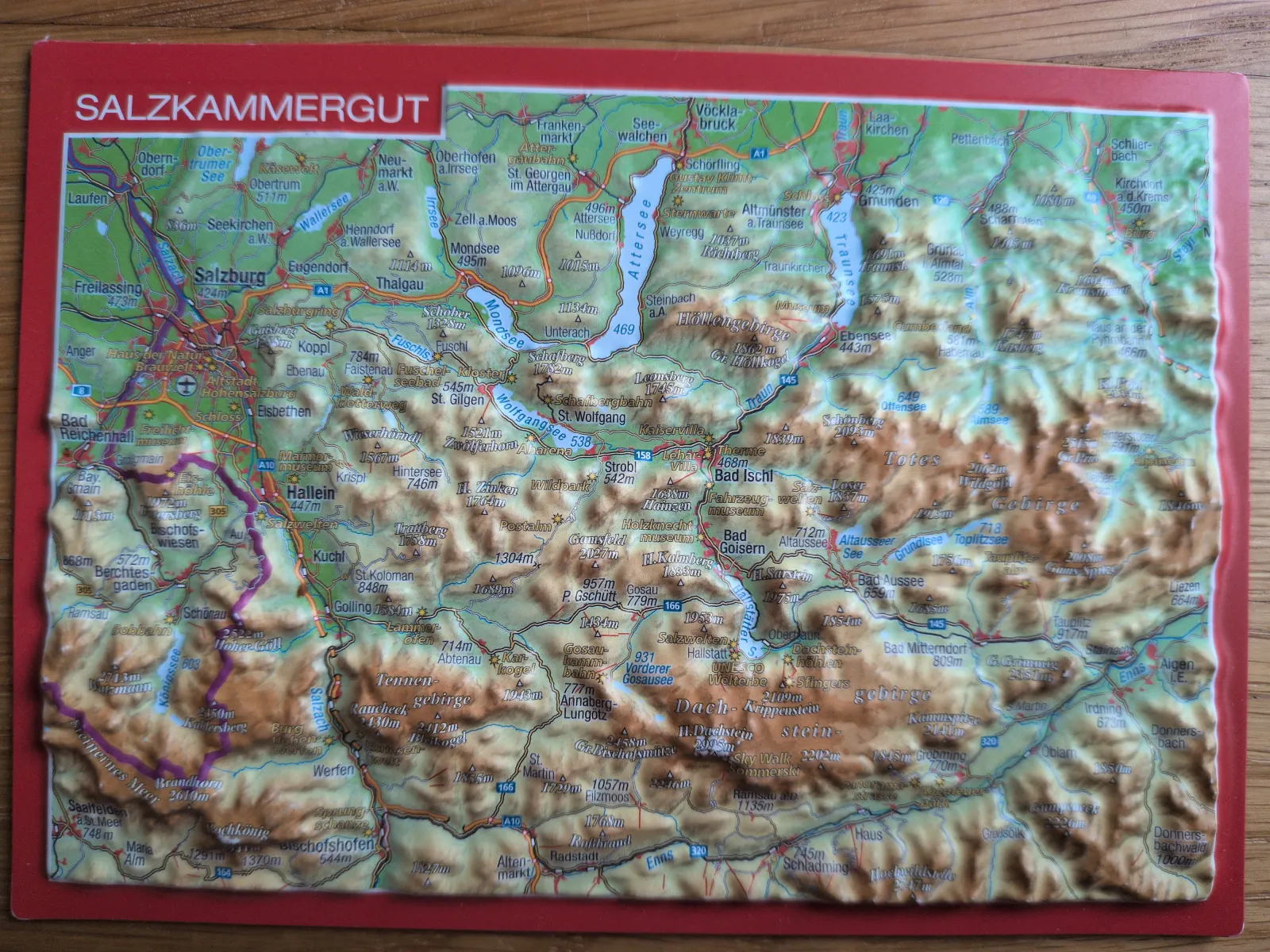 Eine dreidimensionale Reliefkarte des Salzkammerguts zeigt Berge, Seen und Ortschaften.