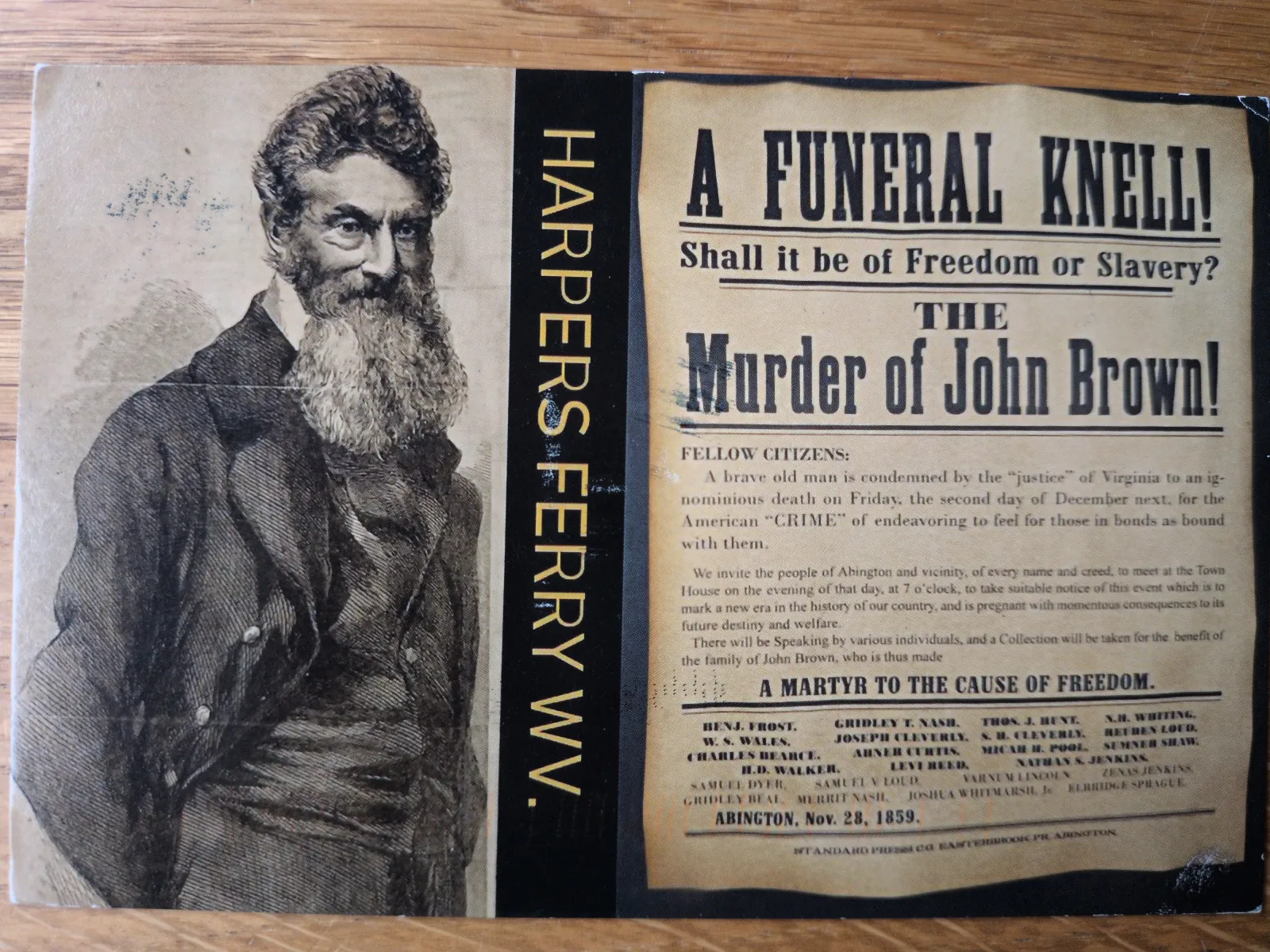 Ein historisches Dokument zeigt links ein Porträt des bärtigen John Brown, in der Mitte den vertikalen Schriftzug "HARPERS FERRY WV" und rechts einen Protesttext von 1859, der seinen "Mord" anprangert.