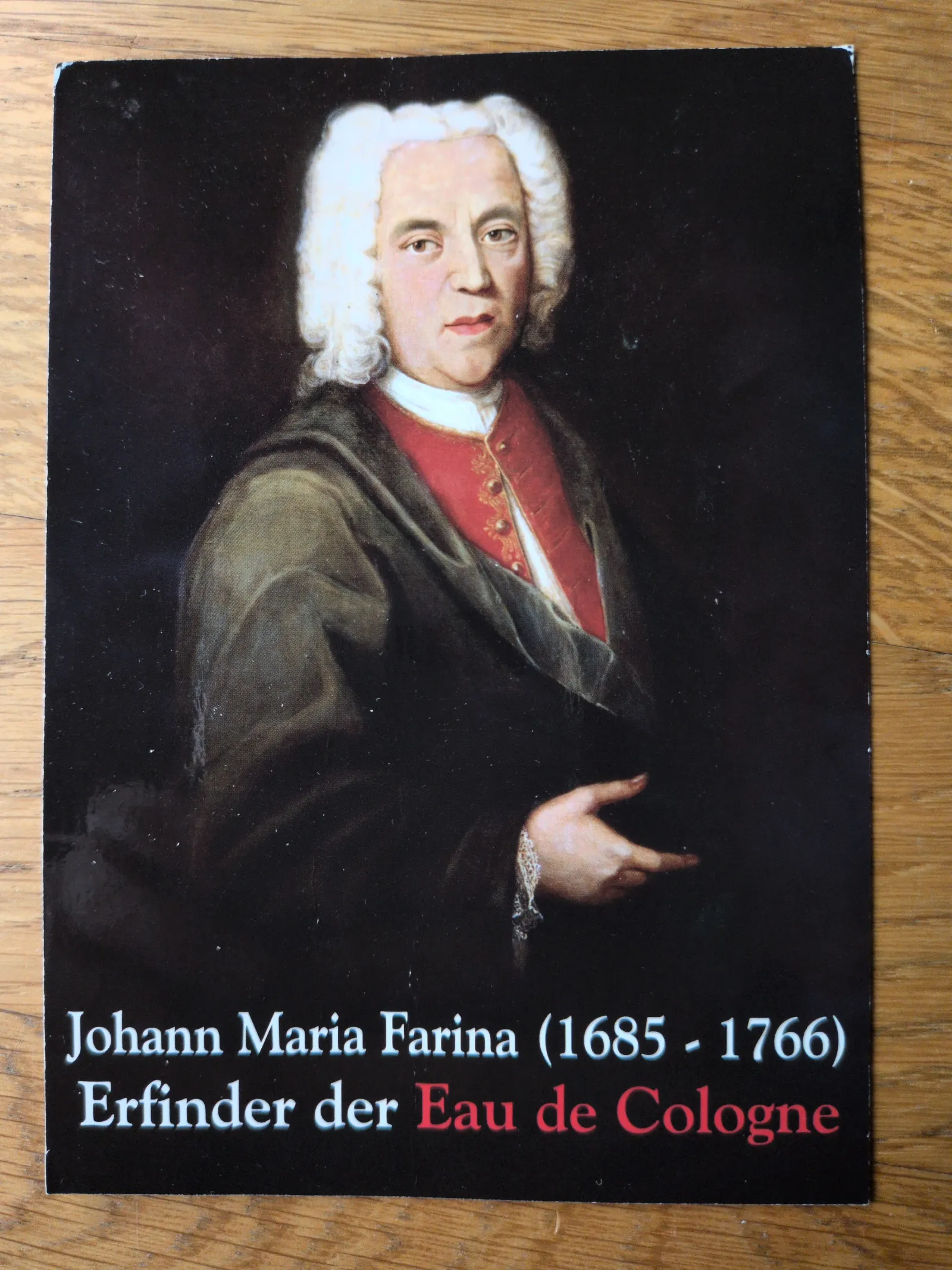 Ein Porträt zeigt Johann Maria Farina (1685-1766), den Erfinder des Eau de Cologne, in historischer Kleidung mit weißer Perücke.