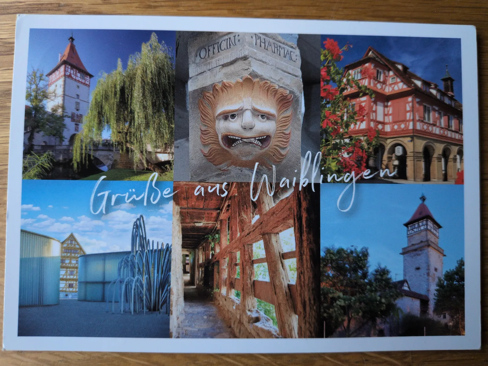 Eine Postkarten-Collage mit sechs Stadtansichten von Waiblingen, darunter historische Türme und Fachwerkhäuser, eine groteske Steinmaske und moderne Bauten, überlagert vom Schriftzug "Grüße aus Waiblingen".