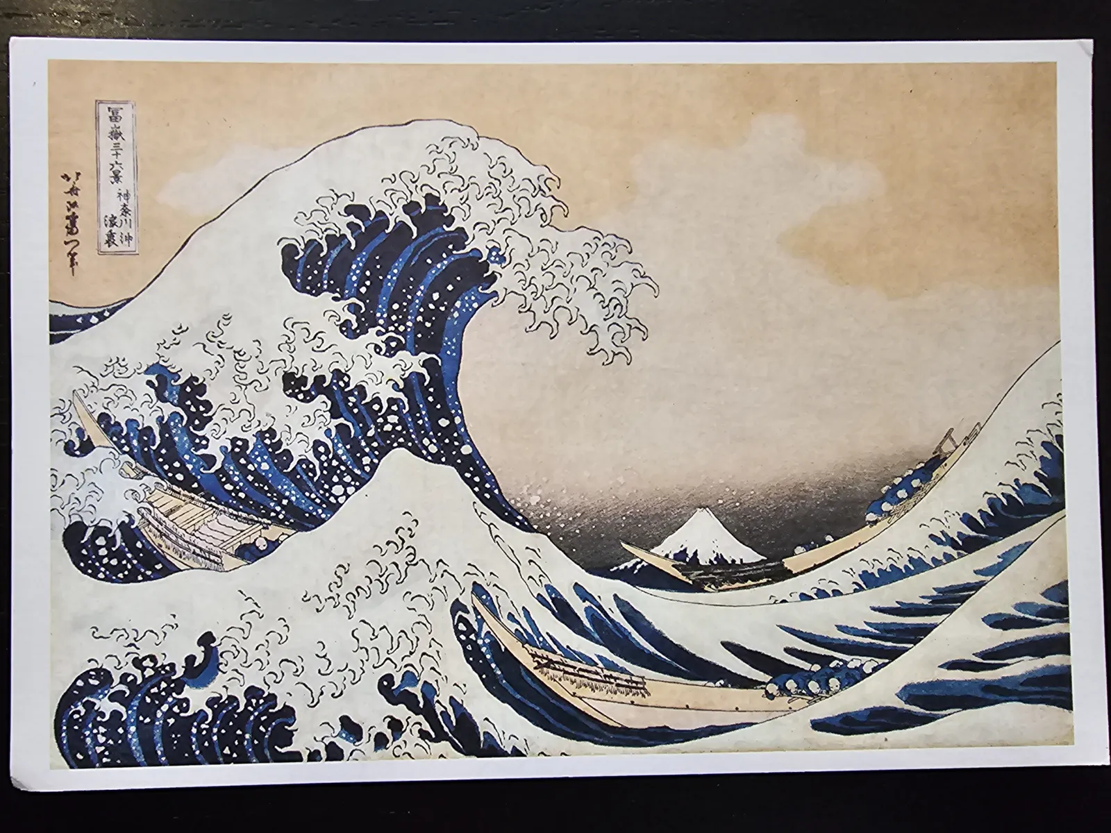 Der berühmte japanische Holzschnitt von Hokusai zeigt eine riesige blaue Welle, die Boote bedroht, mit dem Berg Fuji im Hintergrund.