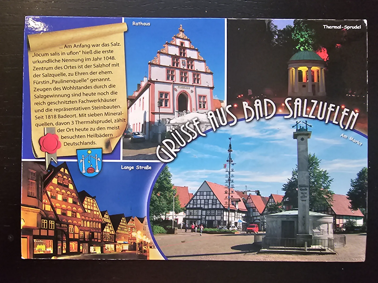Eine Postkarten-Collage zeigt verschiedene Ansichten von Bad Salzuflen, darunter das Rathaus, Fachwerkhäuser, einen Thermal-Sprudel und den Marktplatz, teils bei Tag und teils bei Nacht.