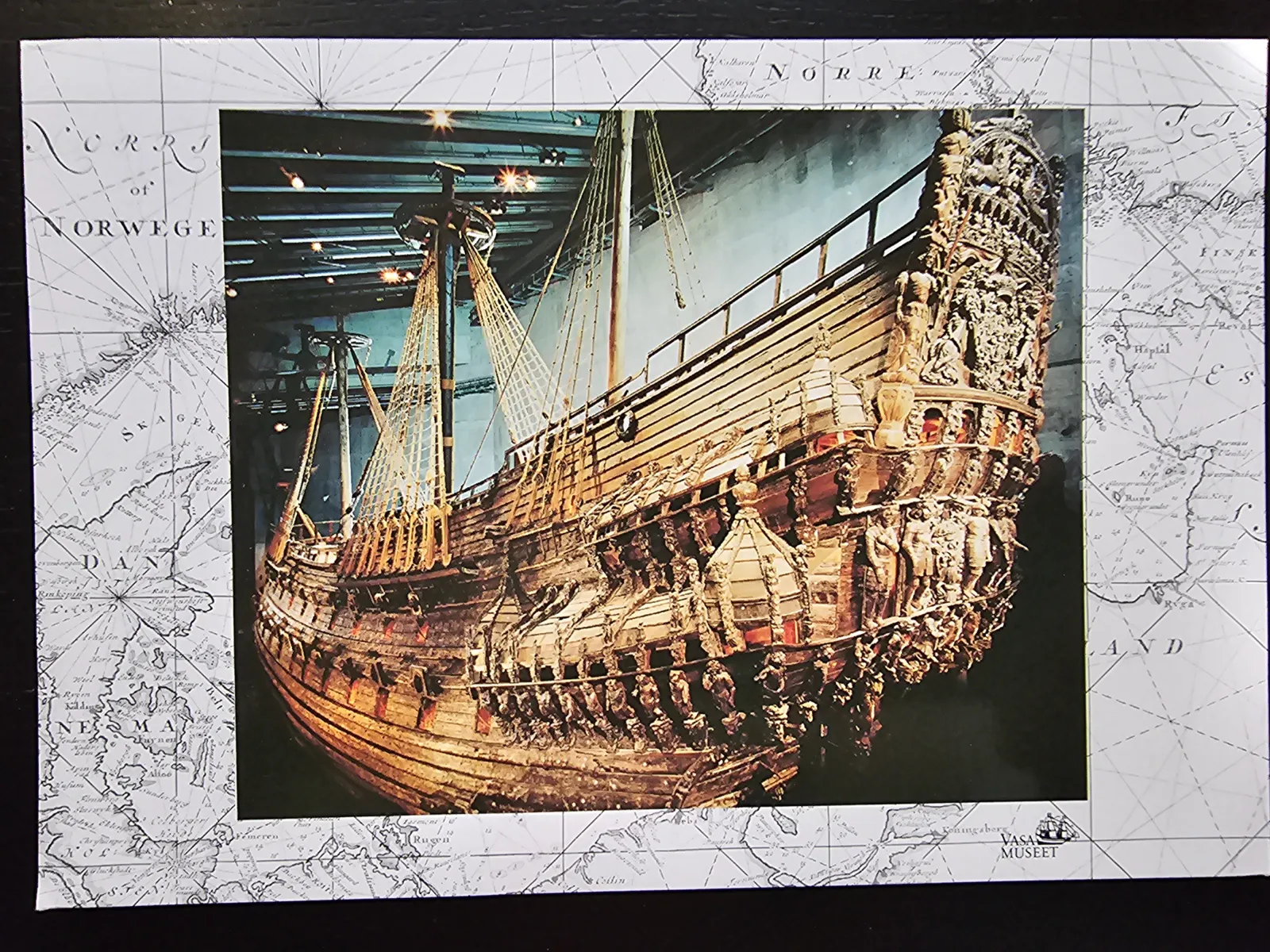 Das Bild zeigt das gut erhaltene, reich verzierte Holzschiff Vasa mit Masten und Takelage in einem Museum.