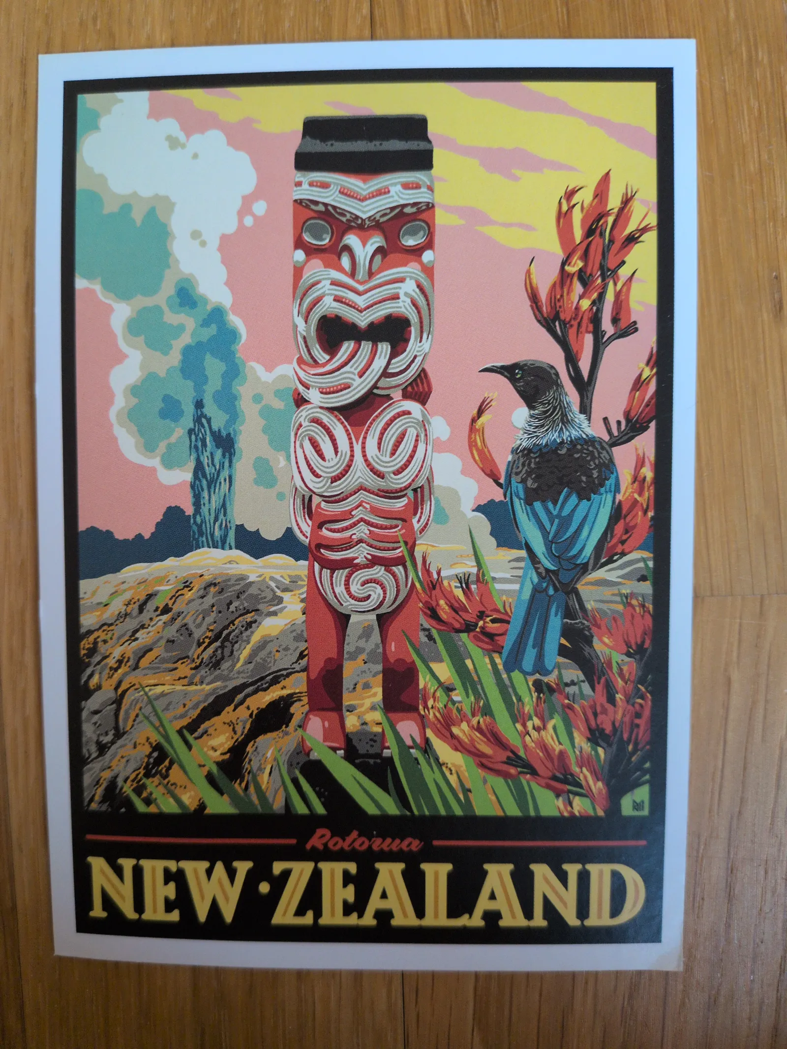 Ein stilisiertes Neuseeland-Poster zeigt eine rote Māori-Schnitzerei, einen blauen Tūī-Vogel, rote Flachsblüten und dampfende Geysire vor einem bunten Himmel, mit der Aufschrift „NEW ZEALAND“.