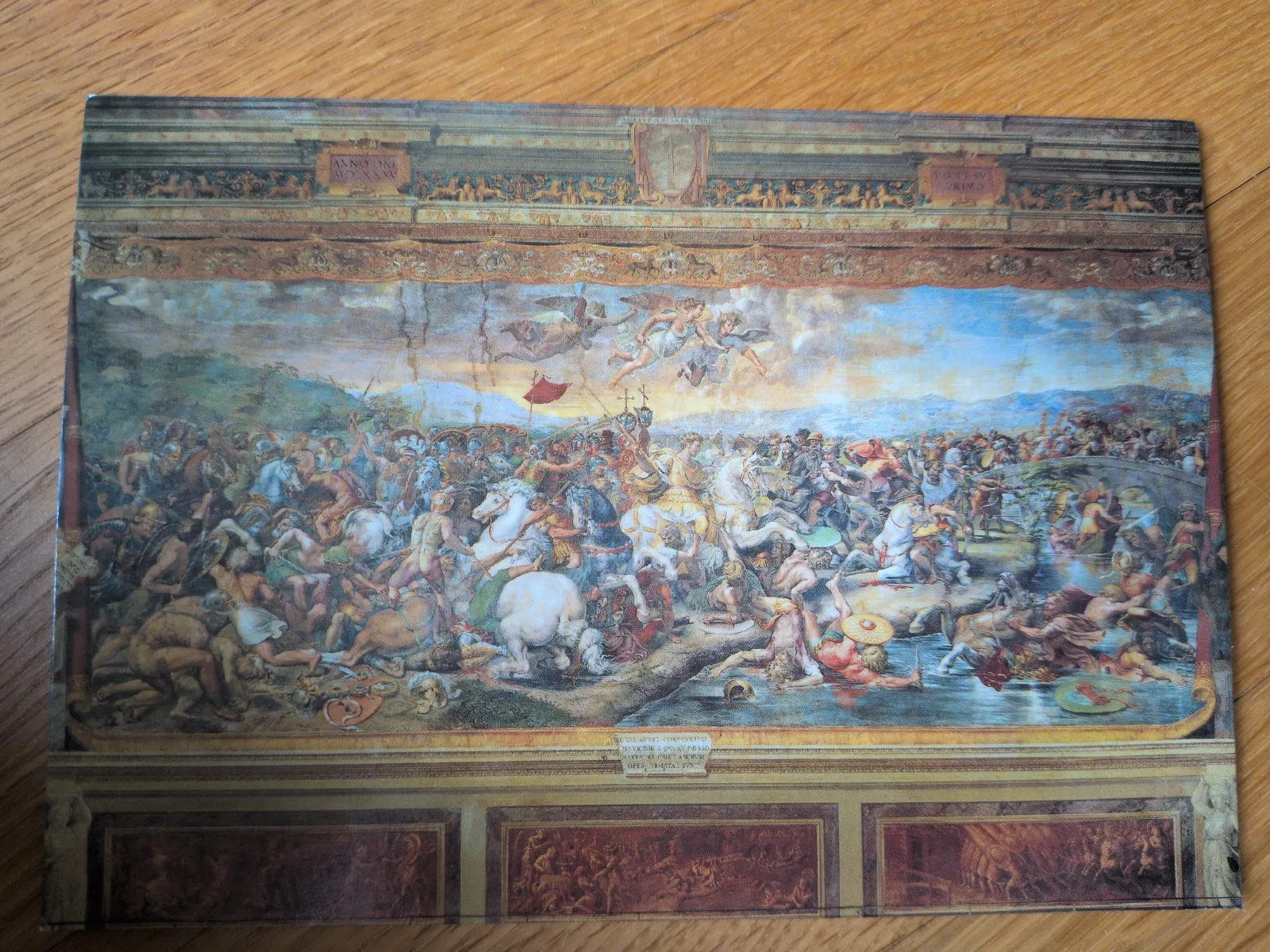 Ein detailreiches, historisches Gemälde zeigt eine große Schlacht mit vielen Kämpfern und Pferden, umgeben von einem verzierten Rahmen.