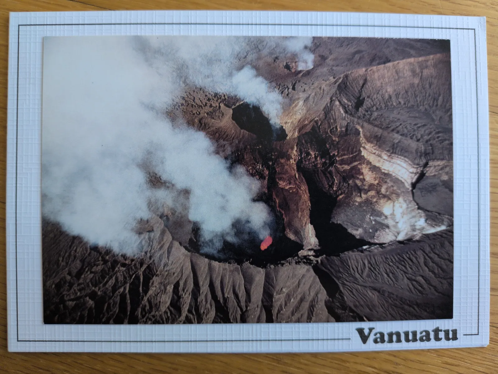 Ein Luftbild zeigt einen rauchenden Vulkankrater mit glühender Lava in Vanuatu.