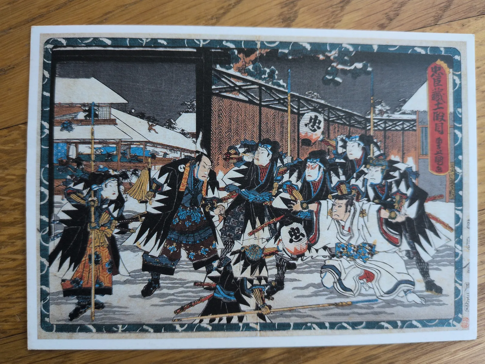 Ein Ukiyo-e-Holzschnitt zeigt eine Gruppe von Samurai in einer dramatischen Auseinandersetzung in einer verschneiten Winternacht vor traditionellen japanischen Gebäuden.