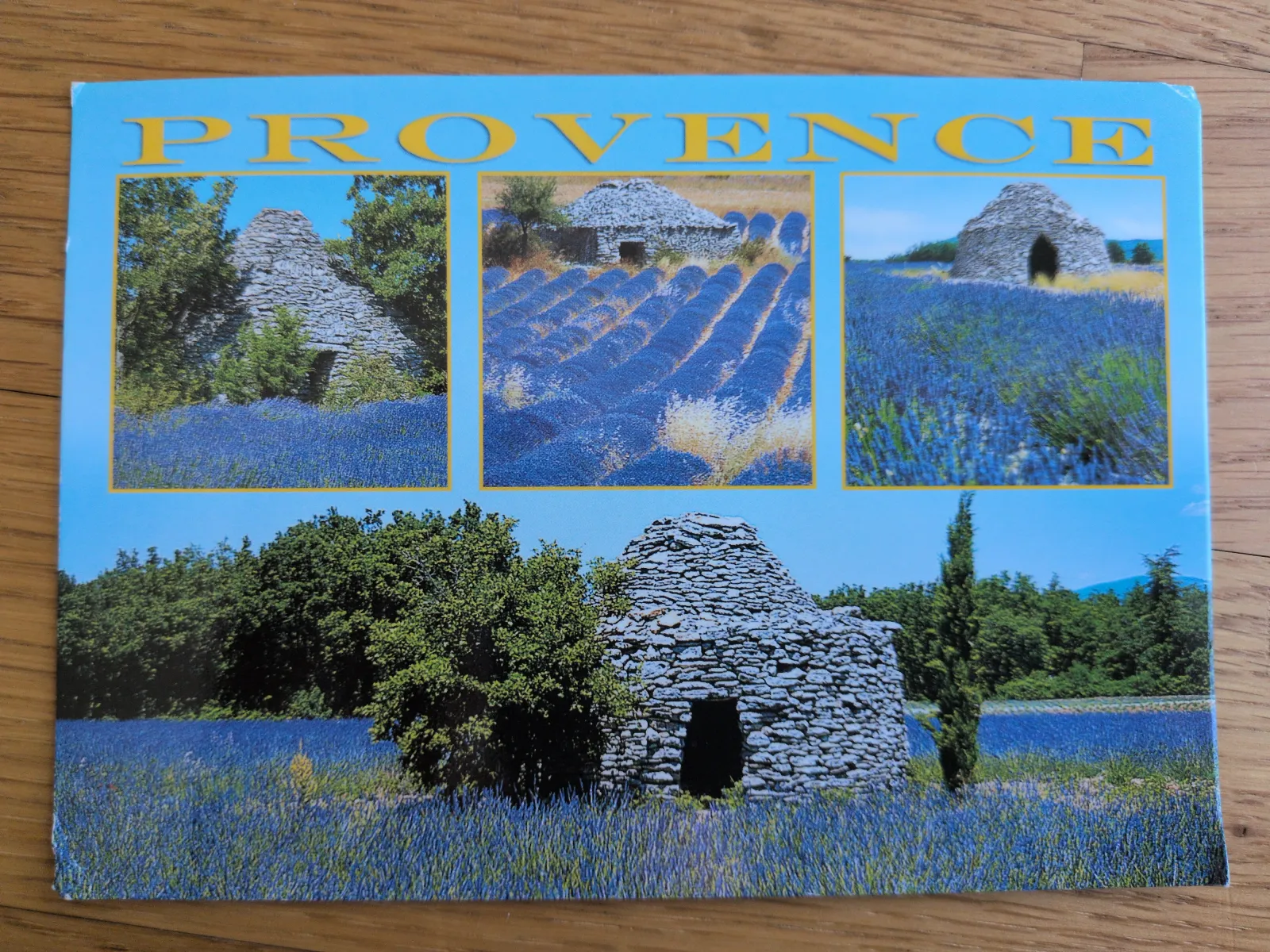 Eine Postkarte mit dem Schriftzug „PROVENCE“ zeigt lila Lavendelfelder und traditionelle Steinhütten.