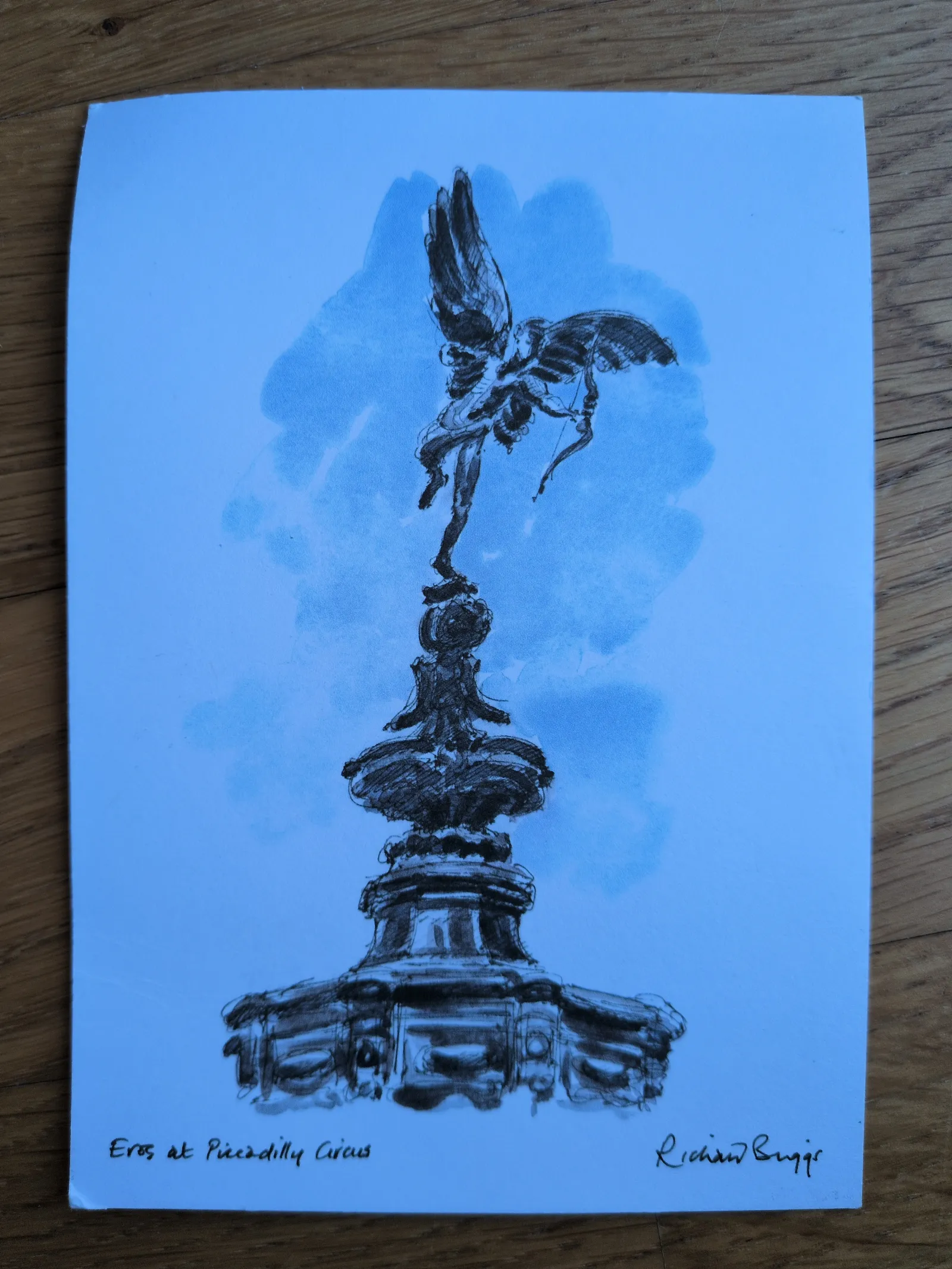 Eine schwarze Skizze der geflügelten Eros-Statue mit Bogen auf einem verzierten Sockel, vor einem hellblauen Hintergrund, betitelt „Eros at Piccadilly Circus“.