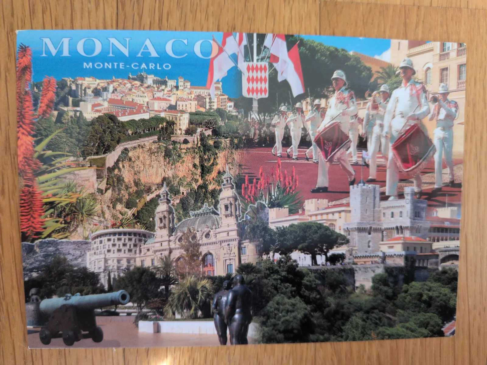 Eine bunte Collage-Postkarte von Monaco und Monte-Carlo zeigt verschiedene Ansichten der Stadt mit berühmten Gebäuden, einer Militärparade und üppiger Vegetation.