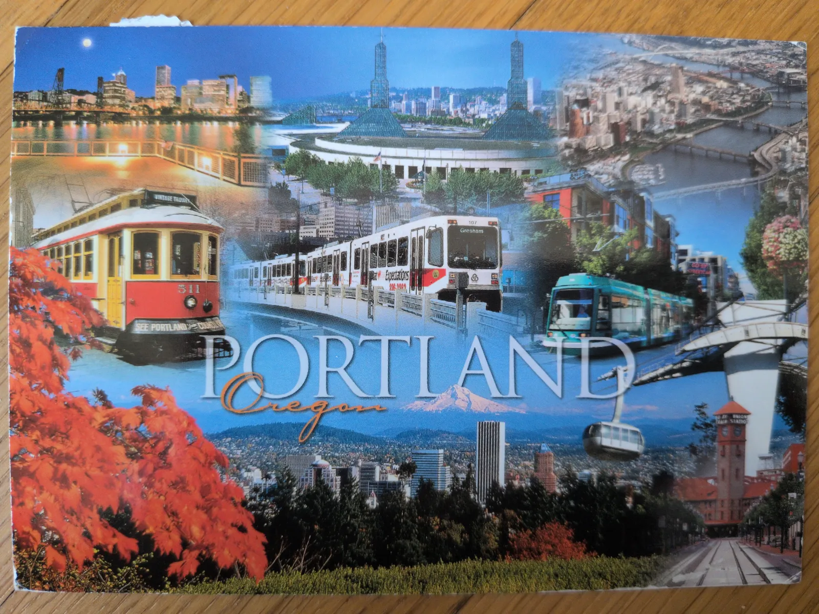 Eine Collage zeigt verschiedene Stadtansichten von Portland, Oregon, darunter Brücken, Straßenbahnen, Natur und den Schriftzug „PORTLAND Oregon“.