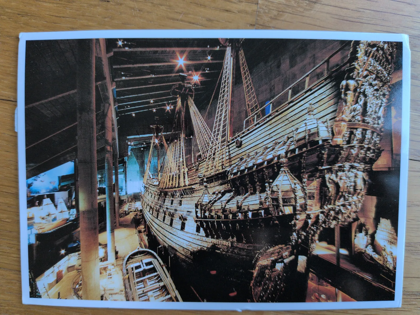 Ein großes, reich verziertes Holzsegel-Schiff mit Masten und Takelage ist in einem dunklen Museum ausgestellt.