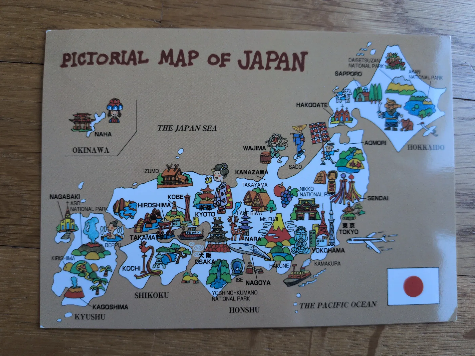 Eine bunte Bildkarte Japans zeigt die Inseln mit typischen Wahrzeichen, Städten und der japanischen Flagge.