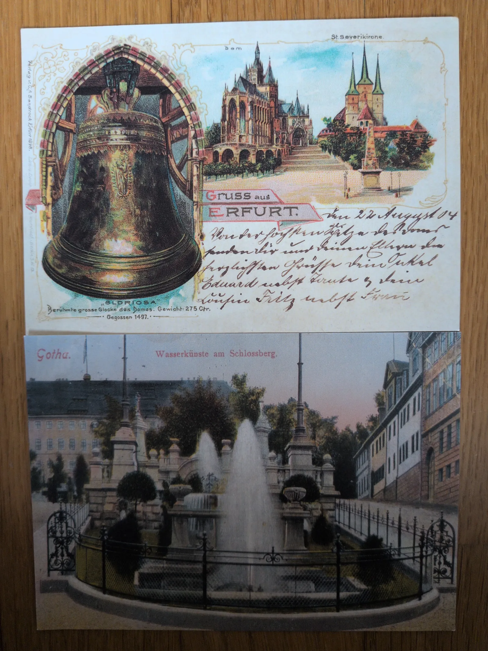 Das Bild zeigt zwei alte, farbige Postkarten mit Ansichten deutscher Städte: oben Erfurt mit Dom und Glocke, unten Gotha mit einem Springbrunnen.