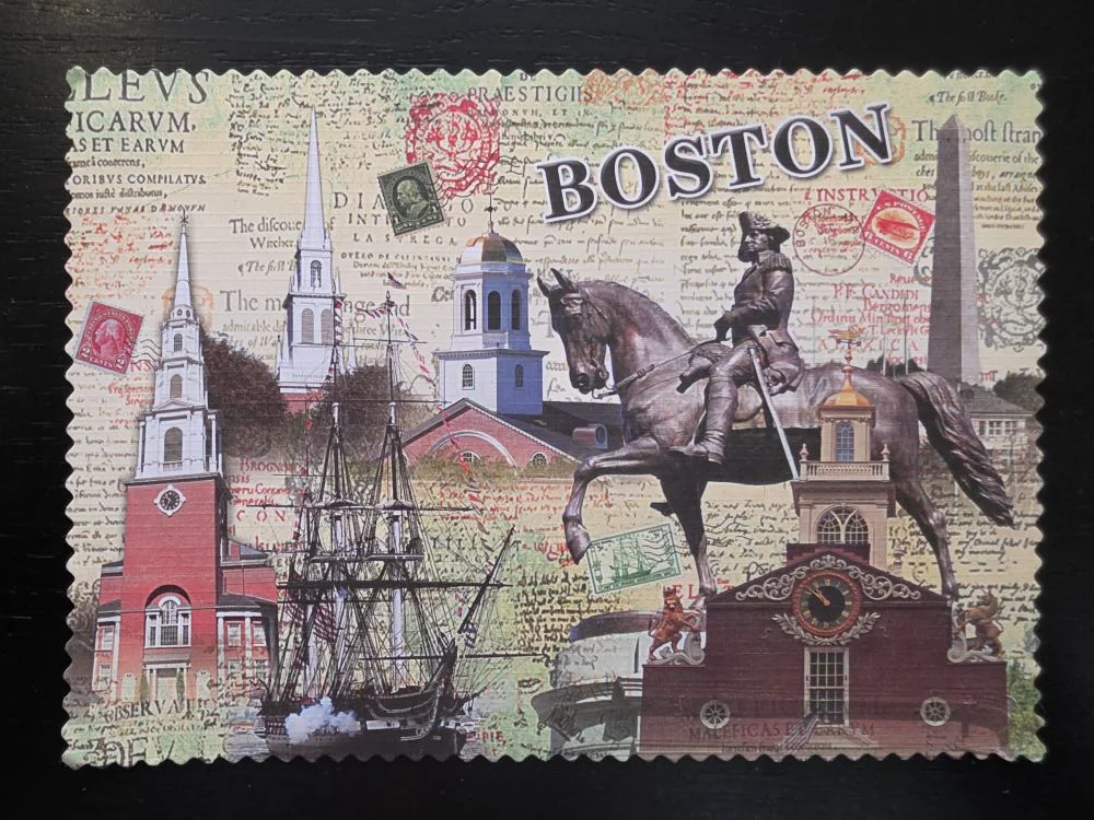 Eine Collage im Stil einer gezackten Briefmarke zeigt historische Wahrzeichen von Boston, darunter das George-Washington-Reiterstandbild, die Old North Church und ein Segelschiff vor einem vintage-artigen Schrifthintergrund.