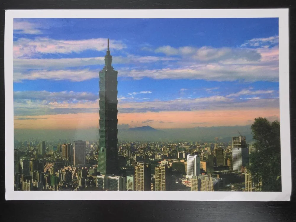 Der markante Wolkenkratzer Taipei 101 ragt inmitten der dichten Stadtlandschaft von Taipeh unter einem blau-rosa gefärbten Himmel empor.