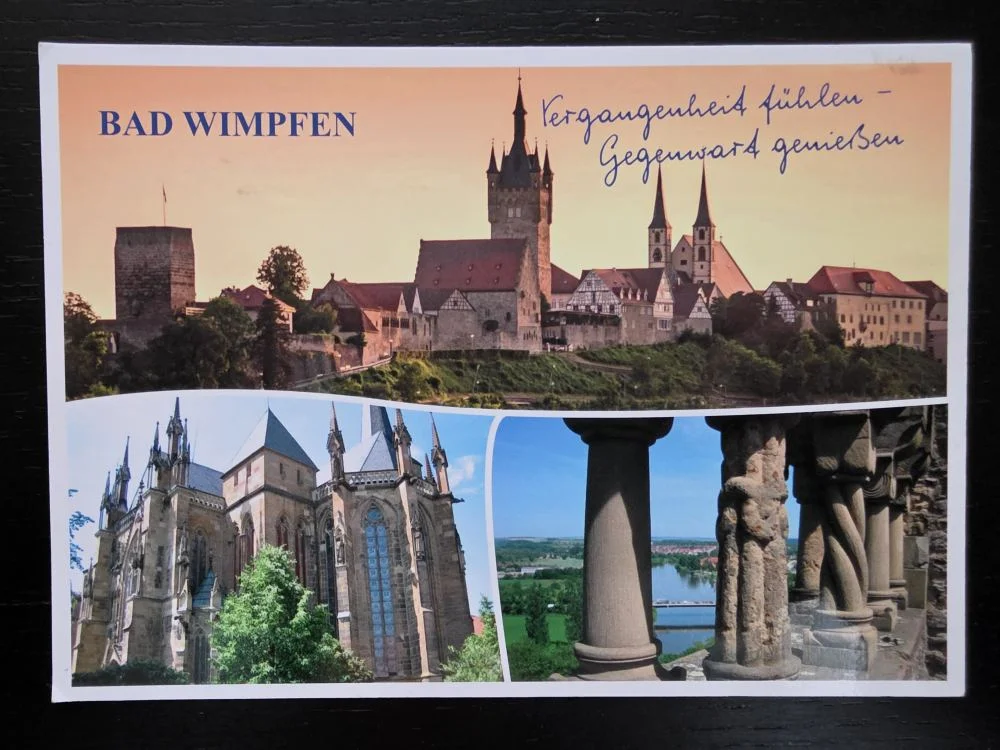 Eine Postkarte von Bad Wimpfen, die in drei Bildern die historische Stadtsilhouette im Abendlicht, eine gotische Kirche und einen Ausblick durch steinerne Säulen zeigt.