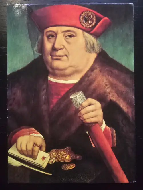 Ein Gemälde zeigt einen korpulenten Mann in rotem Hut und Pelzmantel, der einen Stab hält und von Goldmünzen und Papieren umgeben ist.