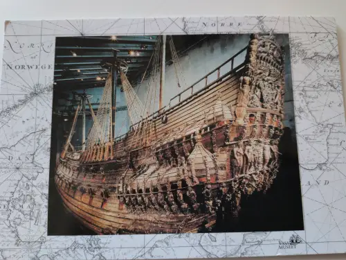 Das Bild zeigt das große, reich verzierte Holzschiff Vasa, ausgestellt in einem Museum.