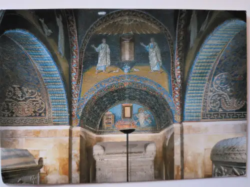 Ein reich verzierter Raum ist zu sehen, dessen Wände und Decke mit farbigen Mosaiken von Figuren und Mustern bedeckt sind, mit steinernen Sarkophagen im unteren Bereich.