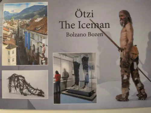Das Bild zeigt eine Rekonstruktion von Ötzi dem Eismann, umgeben von Fotos seiner Fundstücke und einer Stadtansicht von Bozen.