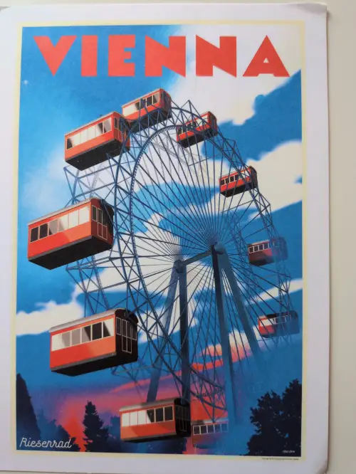 Ein Vintage-Poster zeigt das Wiener Riesenrad mit roten Gondeln vor einem blau-roten Himmel und dem Schriftzug „VIENNA“.