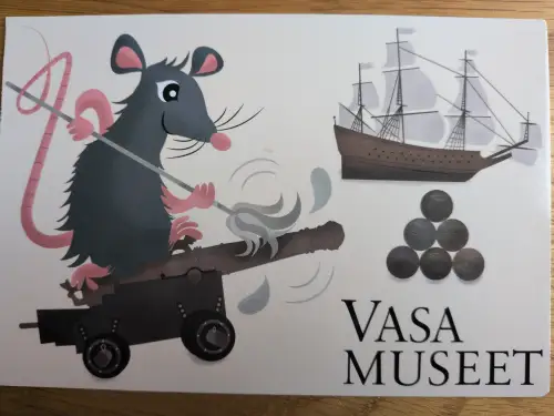 Ein Cartoon-Bild zeigt eine Ratte, die eine Kanone lädt, neben einem Segelschiff, Kanonenkugeln und dem Schriftzug „VASA MUSEET“.
