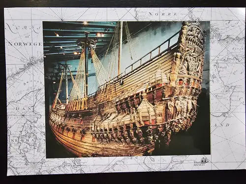 Das Bild zeigt das gut erhaltene, reich verzierte Holzschiff Vasa mit Masten und Takelage in einem Museum.