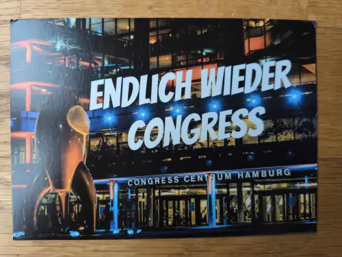 Das beleuchtete Congress Centrum Hamburg bei Nacht mit einer Raketenskulptur und den Texten "ENDLICH WIEDER CONGRESS" und "CONGRESS CENTRUM HAMBURG".