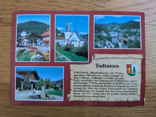 Eine Postkarte präsentiert den Schwarzwaldort Todtmoos in mehreren Bildern mit seiner Kirche, Häusern und grüner Landschaft, begleitet von einem erklärenden Text.